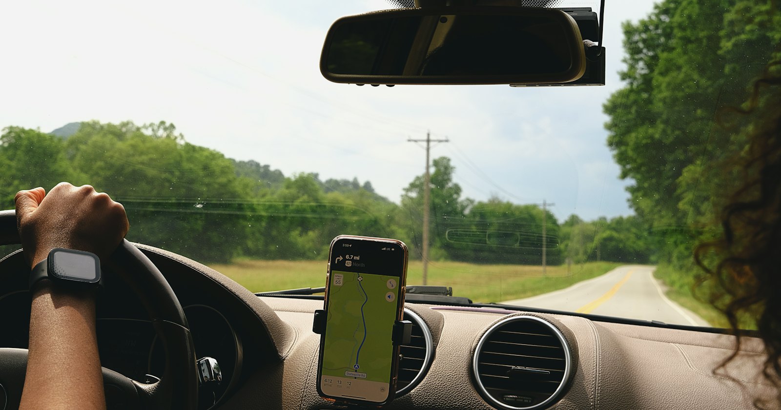 Vrouw aan het rijden met een telefoon in haar hand