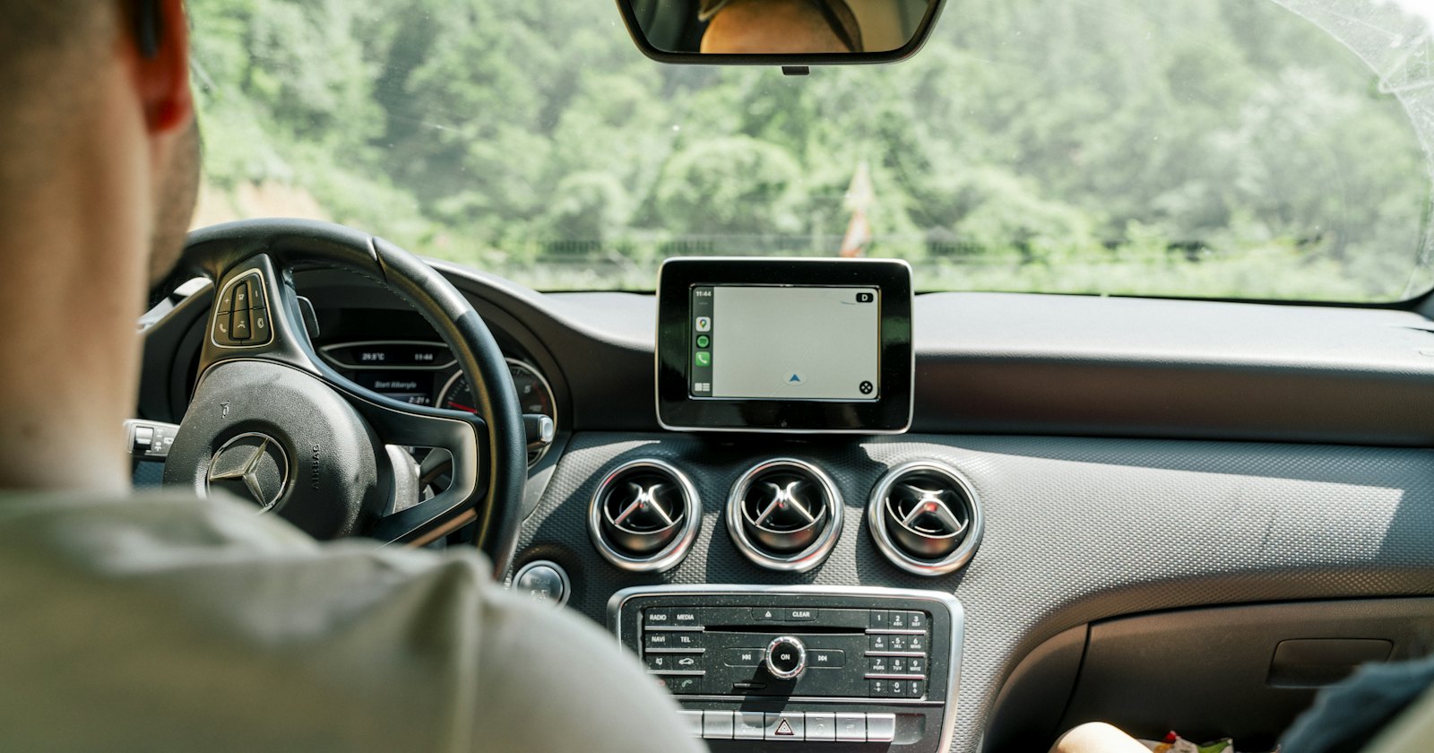 Automobilist bedient gps-navigatieapparaat tijdens het rijden