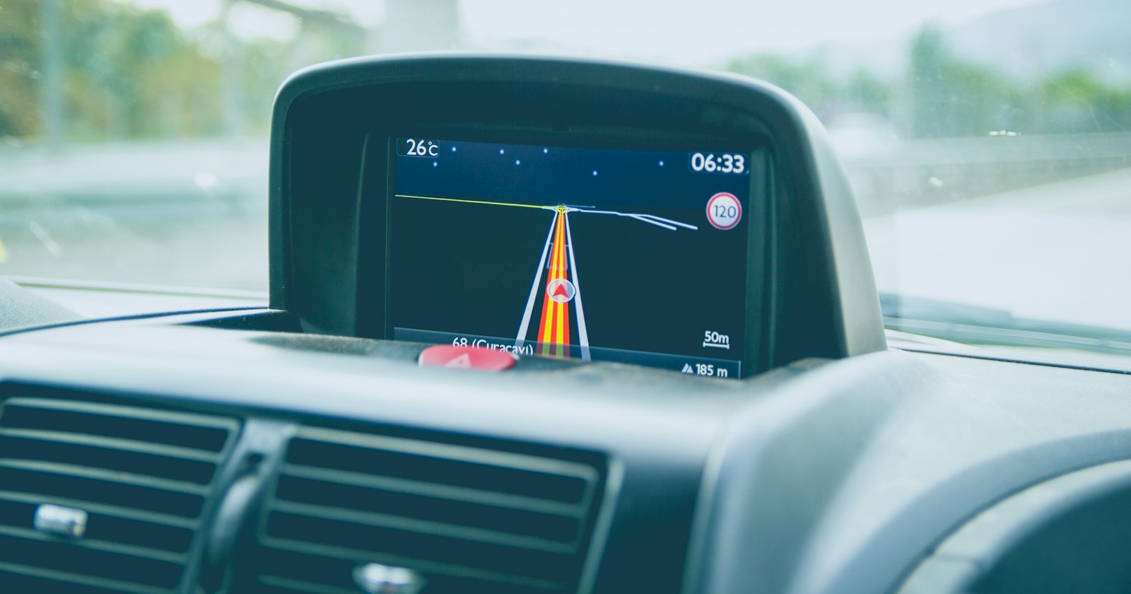 GPS-Navigationsdisplay in schwarzem Fahrzeug bei Tageslicht